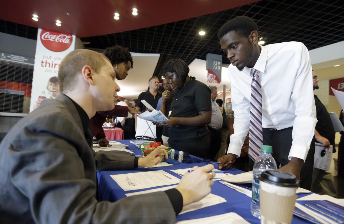 A job seeker attending a career fair in Sunrise, Fla., in June listens to a representative from Teleperformance, an organization that identifies itself on its corporate website as "the global leader in outsourced multichannel customer experience management."