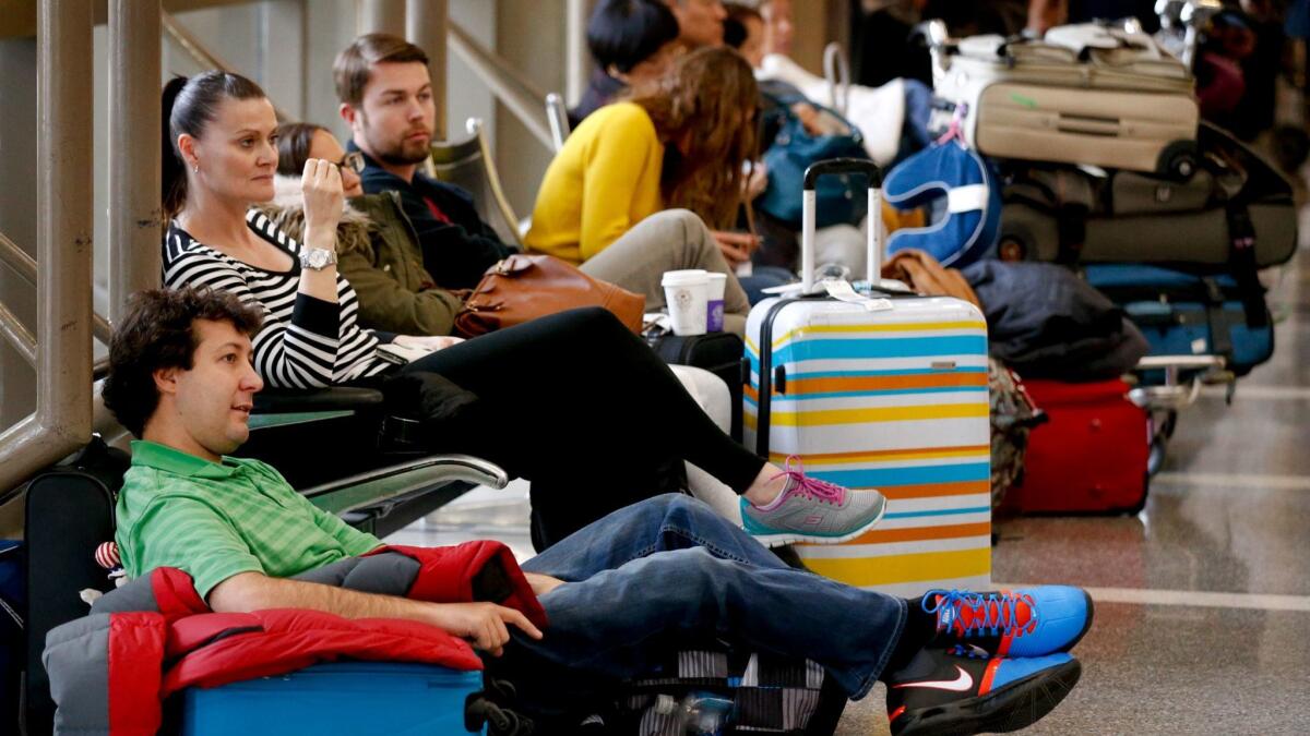 Travelers wait for their flights inside the Bradley Terminal at Los Angeles International Airport. The airport has announced training for employees to give travelers "gold standard" service. (Mark Boster / Los Angeles Times)