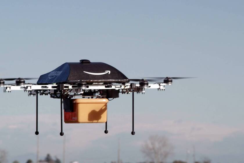 An unmanned aerial vehicle carrries a package from Amazon. The company plans to offer a service called Prime Air that would deliver products to buyers in minutes. But such a service faces several hurdles.