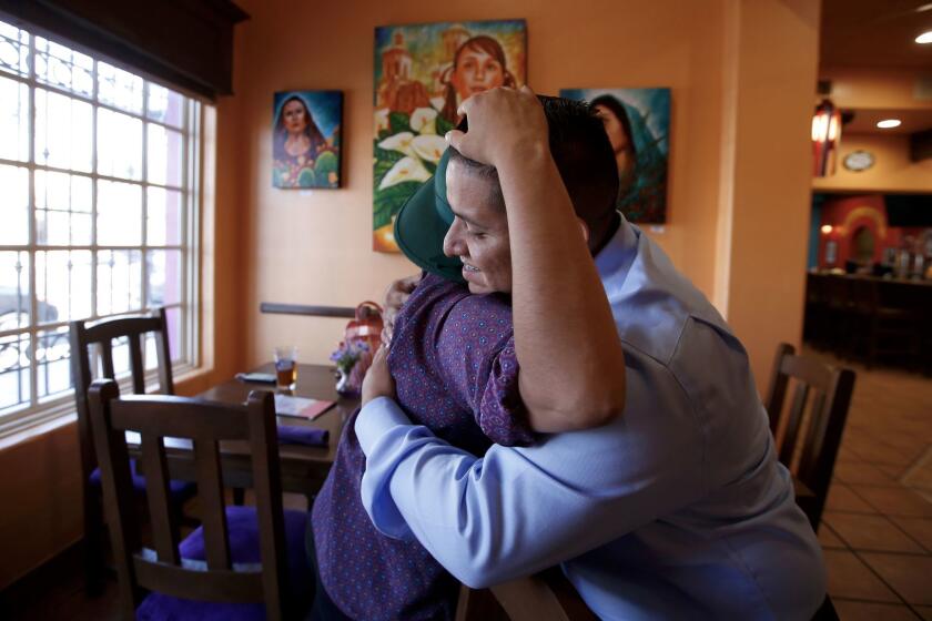 Juan Casas, 28, right, hugs Gloria Plaza, 32, both are DACA participants. Casas has worked the graveyard shift through college to earn an electrical engineering degree and now works for an aerospace company. (Francine Orr/ Los Angeles Times)