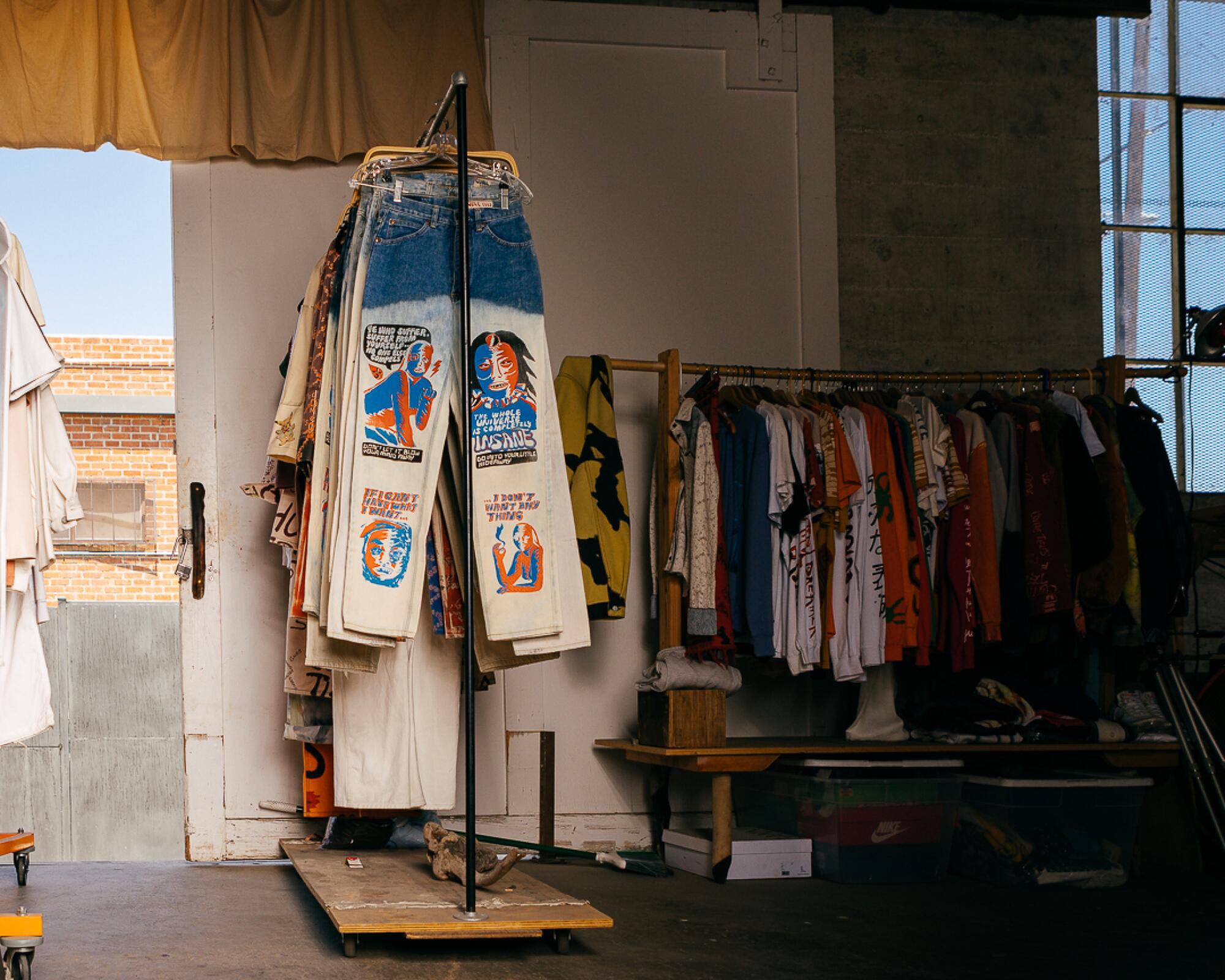 Photo of Come Tees clothes hanging on a rack.