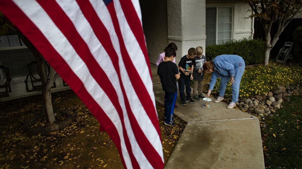 Third-grade teacher Sheri Eichar uses paper plates to teach children how to tell time using a homemade sundial.