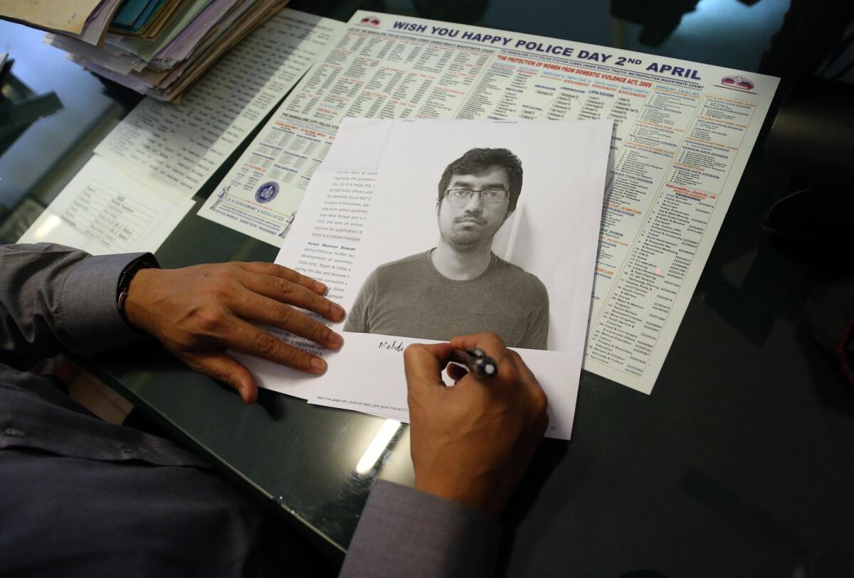 Bangalore police Investigating Officer Hemant Nimbalkar writes on a photograph of Mehdi Masroor Biswas in his police headquarters office in Bangalore, India, on Saturday. Police said Saturday that they have arrested Biswas, a 24-year-old engineer, who has admitted to running a popular pro-Islamic State Twitter account, but added that he appears to have no direct links to the militant group.