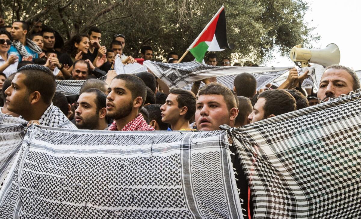 Supporters and relatives of Arab Israelis jailed by an Israeli court Thursday hold keffiyehs, the traditional Arab head dress, outside the court in the coastal city of Haifa. The defendants were convicted in connection with the killing of a far-right soldier in 2005.
