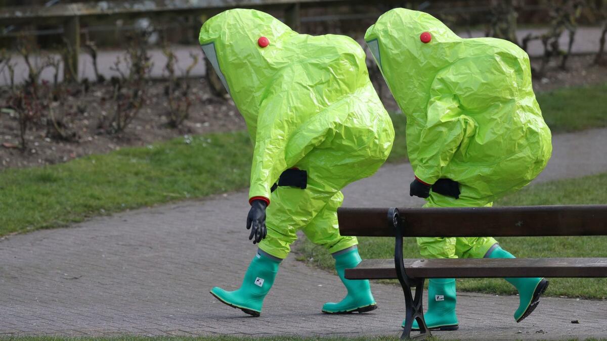 Investigators walk away after securing the covering on a bench in Salisbury, England, where former Russian double agent Sergei Skripal and his 33-year-old daughter, Yulia, were found critically ill by exposure to a nerve agent on Sunday.