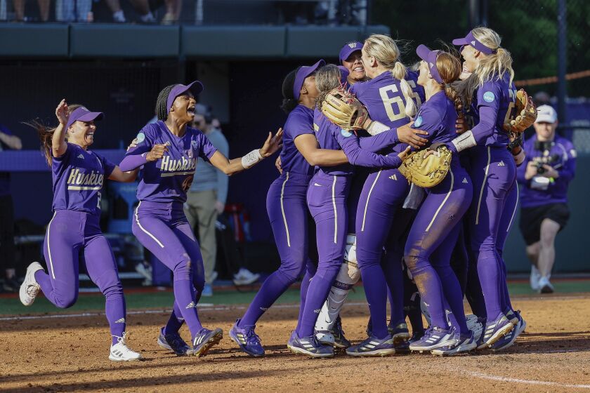 Washington players celebrate after defeating Louisiana-Lafayette in a Super Regionals college softball game in Seattle, Saturday, May 27, 2023. (Dean Rutz/The Seattle Times via AP)