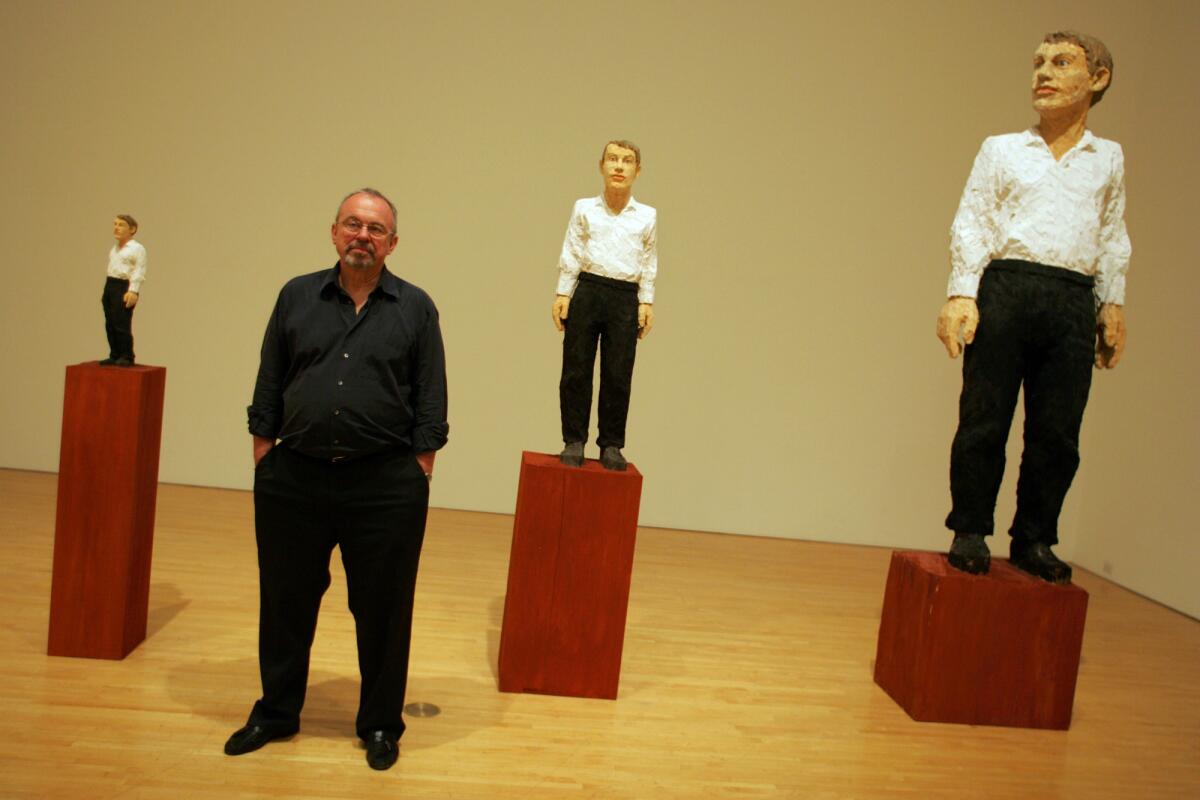 In this 2005 archival photo, Blake Byrne, a retired TV executive, stands next to a sculpture by artist Stephan Balkenhol titled "Vier Figurengruppe," on display at the Museum of Contemporary Art. The sculpture is one of many pieces of art that Byrne has donated to MOCA.