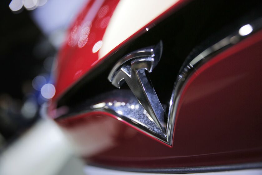 FILE - This Friday, Sept. 30, 2016, file photo shows the logo of the Tesla Model S on display at the Paris Auto Show in Paris. A Minnesota man is blaming Tesla’s partially self-driving Autopilot system for a crash on Saturday, July 15, 2017, in Hawick, Minn. Motorist David Clark told deputies that when he engaged the Autopilot feature, the car suddenly accelerated, left the roadway and overturned in a marsh. Clark and his passengers sustained minor injuries. Tesla said it’s investigating and will cooperate with local authorities. (AP Photo/Christophe Ena, File)