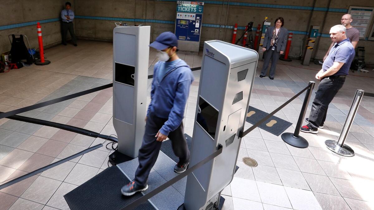 Passenger Nicholas Sanler walks through a screening system Wednesday on his way to the Metro Red and Purple line subways. Metro is running a two-day test to analyze the scanner, created by Evolv Technology.