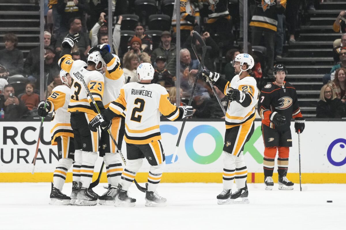Penguins players celebrate after Pierre-Olivier Joseph (73) scored during the first period Feb. 10, 2023, at Honda Center.