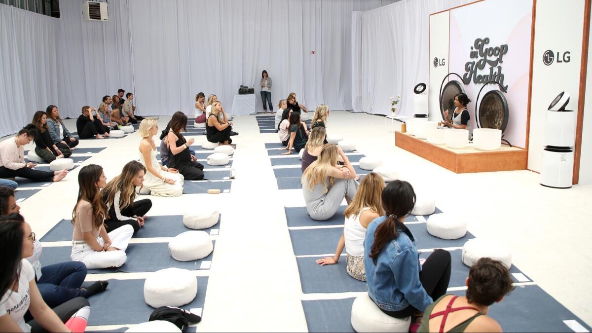 Onstage, Ambi Sitham leads a sound bath at the In Goop Health Summit.