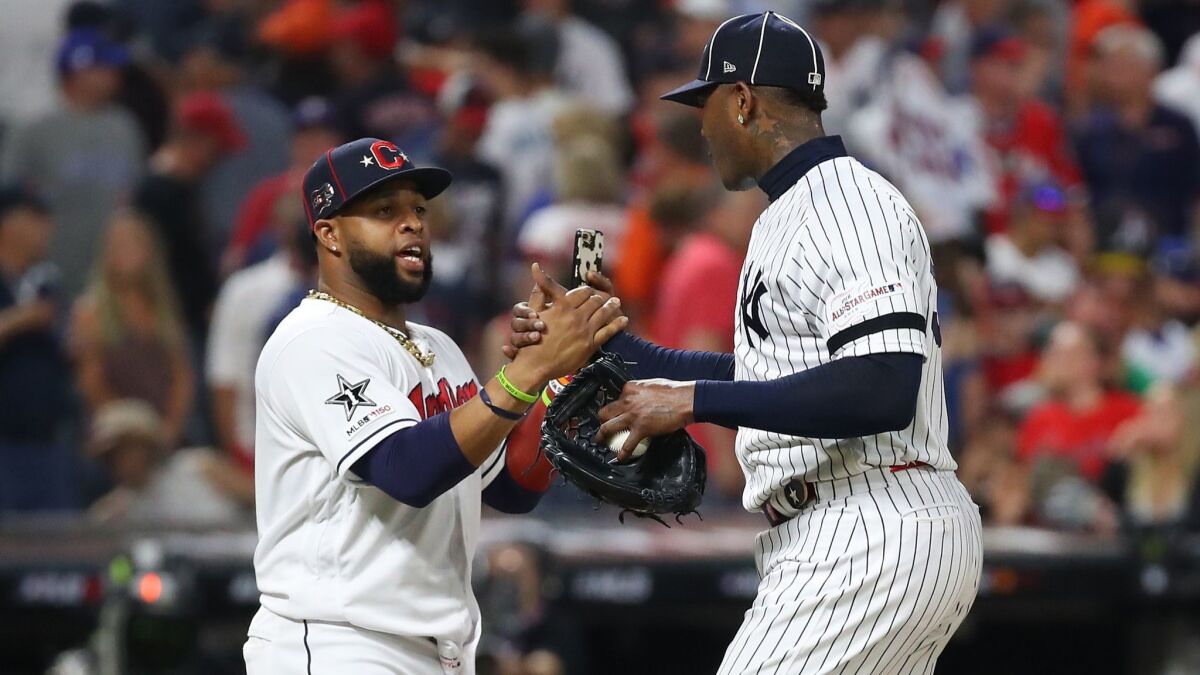 Cleveland Indians' Carlos Santana (41) celebrates with New York Yankees' Aroldis Chapman (54) after the American League defeated the National League 4-3 in the MLB All-Star Game on Tuesday in Cleveland.