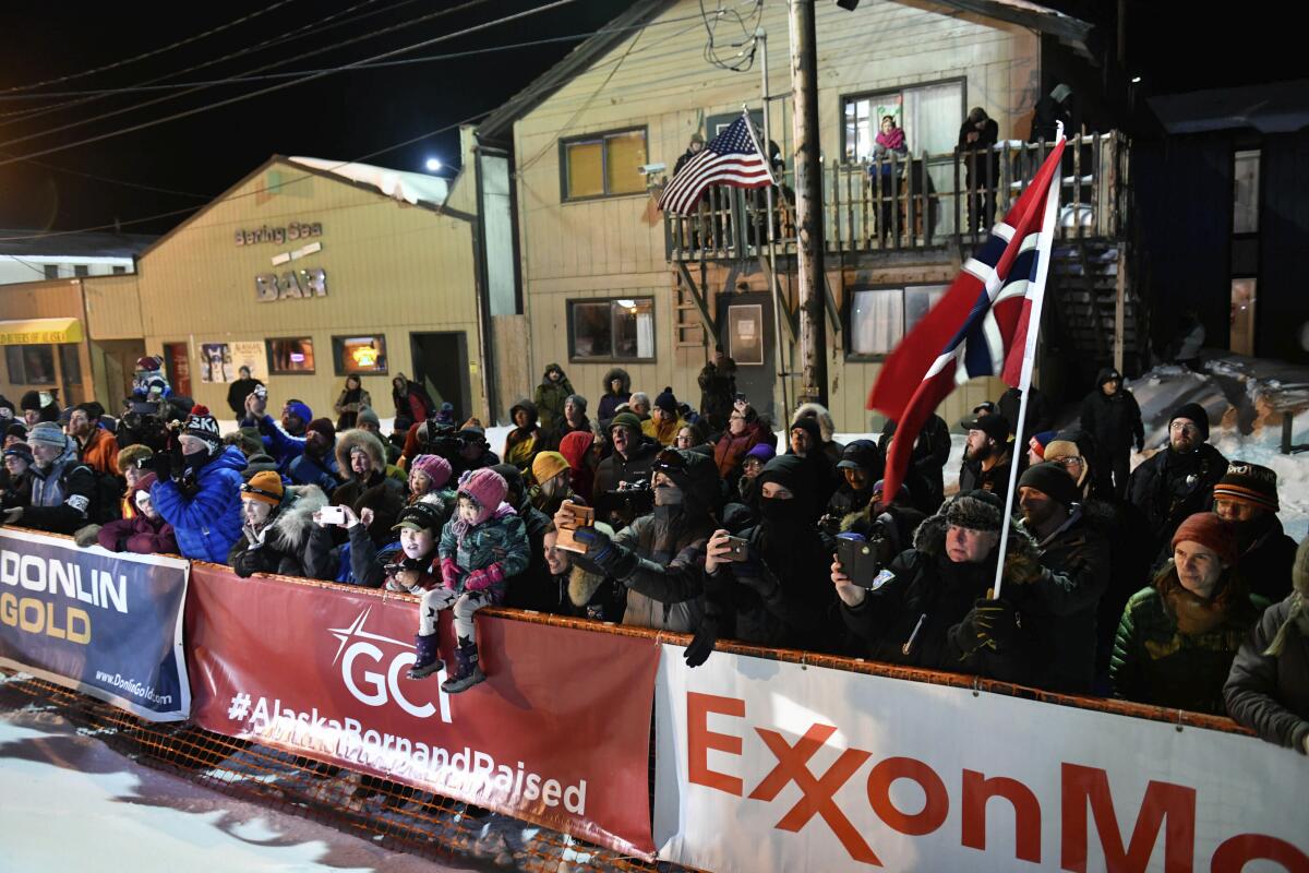 A crowd watches as Thomas Waerner arrives in Nome, Alaska, on March 18 to win the Iditarod sled dog race.