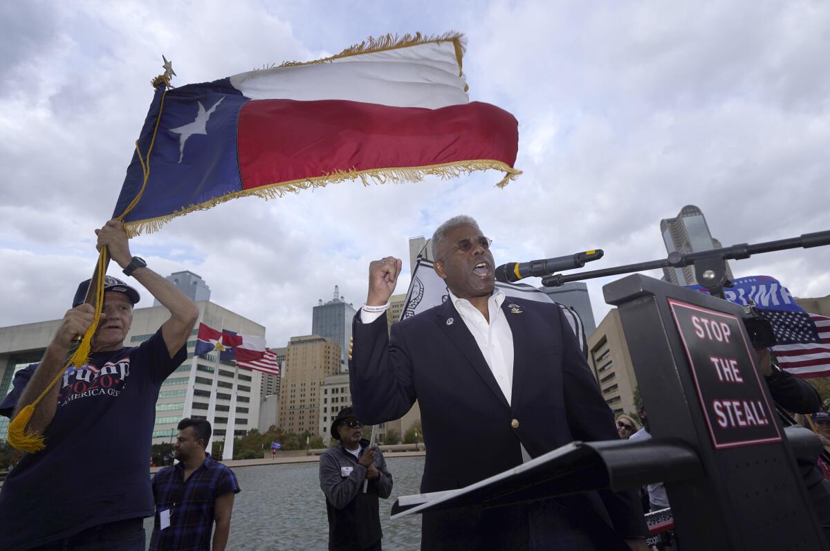 FILE - In this Nov. 14, 2020 file photo, Texas GOP chairman Allen West, right, speaks to supporters of President Donald Trump during a rally in front of City Hall in Dallas. West announced Friday, June 4, 2021, he was stepping down less than a year into a combative tenure of challenging his own party's top leaders, including leading a protest outside Republican Gov. Greg Abbott's mansion. (AP Photo/LM Otero File)
