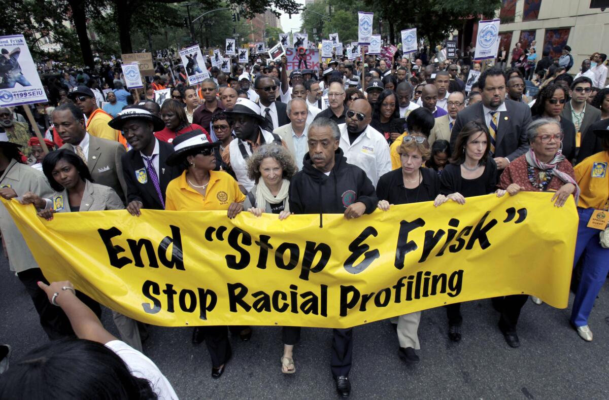 The Rev. Al Sharpton, center, walks with demonstrators during a silent march to end New York's stop-and-frisk program. On Monday, a U.S. District Court judge ruled that the New York Police Department deliberately violated the civil rights of tens of thousands of New Yorkers with its contentious policy, and said an independent monitor is needed to oversee major changes.
