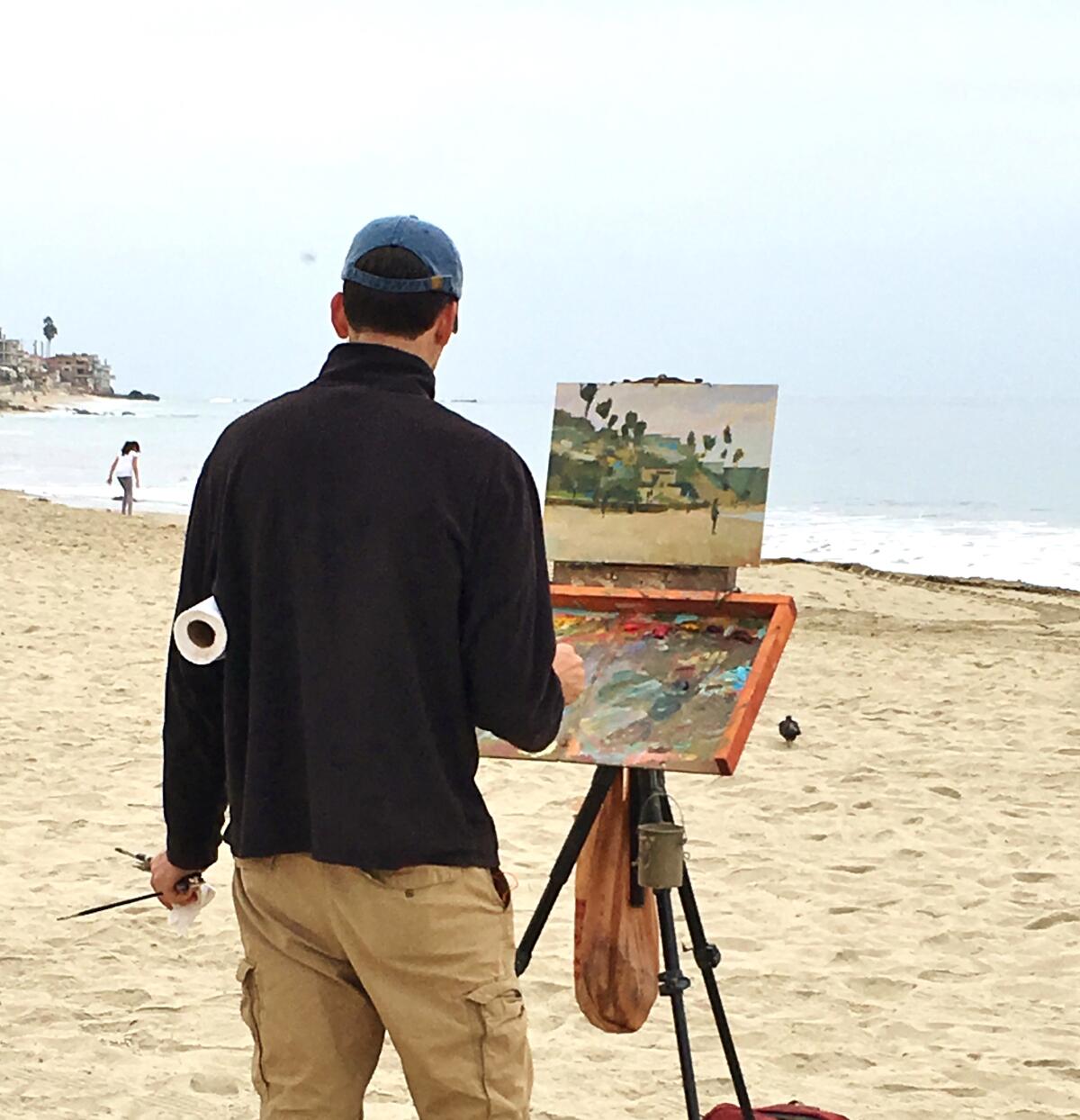 An artist paints a landscape portrait of Main Beach in Laguna Beach.