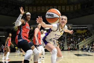 LONG BEACH, CA - MAY 21, 2024: Los Angeles Sparks forward Cameron Brink (22) lunges for a loose ball against Washington Mystics forward Aaliyah Edwards (24) in the first half at Walter Pyramid at Long Beach State on May 21, 2024 in Long Beach, California. (Gina Ferazzi / Los Angeles Times)