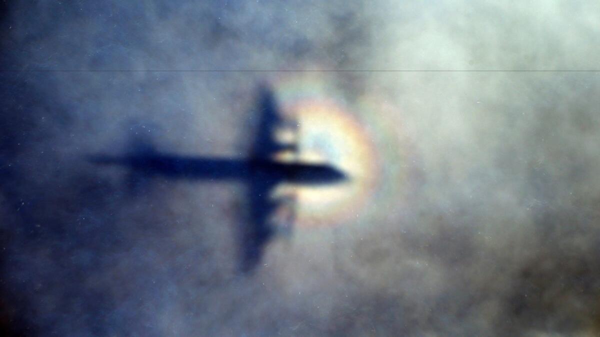 The shadow of a Royal New Zealand Air Force P3 Orion is cast on low-level clouds while the aircraft searches for Malaysia Airlines Flight 370 in the southern Indian Ocean on March 31, 2014.