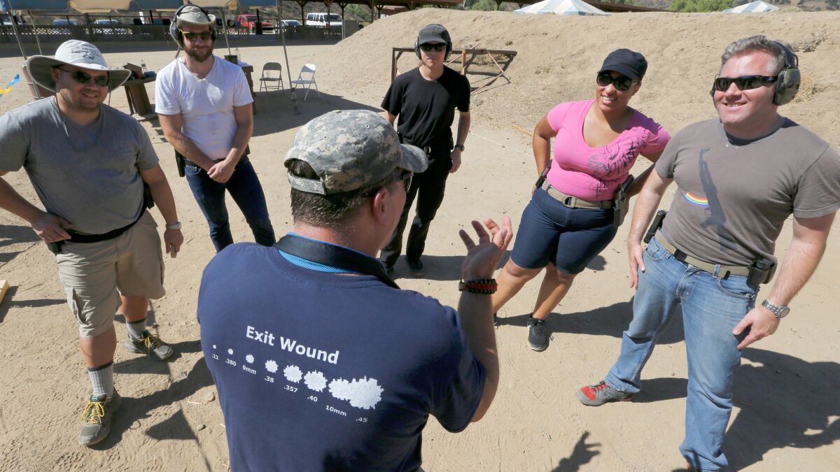 Instructor Jeffrey Bova, center, provides firearms training to a group of gun owners, including West Hollywood Pink Pistols members Elizabeth Southern, second from right, and Jonathan Fischer, right, at a gun range near Piru.