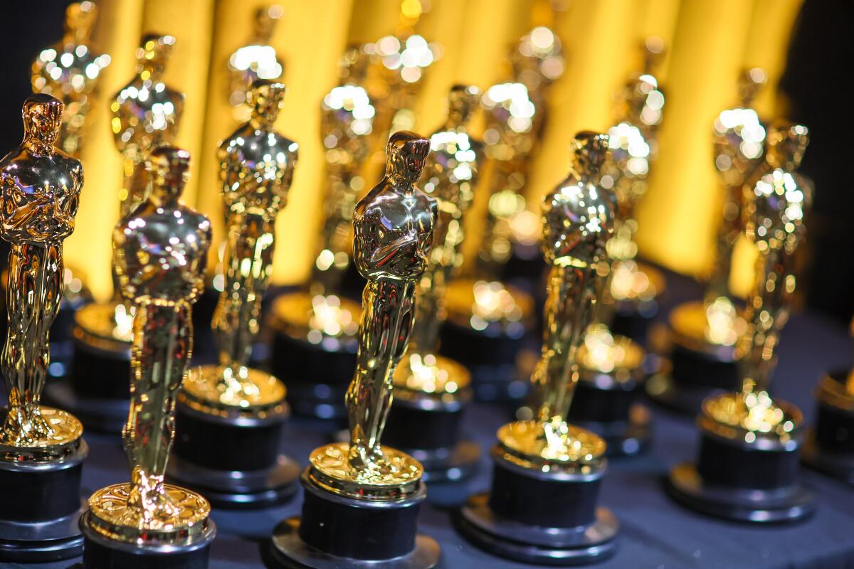Shiny Oscar statuettes on a table