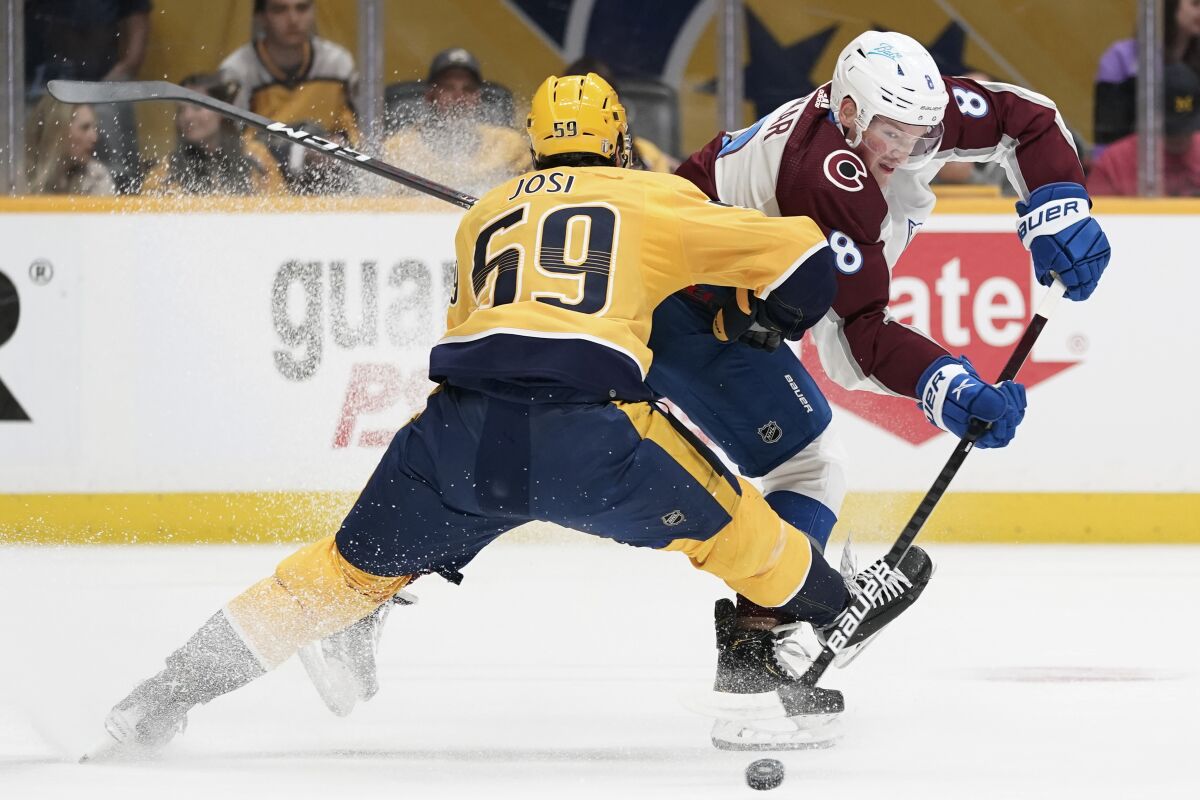 Colorado Avalanche defenseman Cale Makar (8) passes the puck past Nashville Predators' Roman Josi (59) during the first period in Game 4 of an NHL hockey first-round playoff series Monday, May 9, 2022, in Nashville, Tenn. (AP Photo/Mark Humphrey)