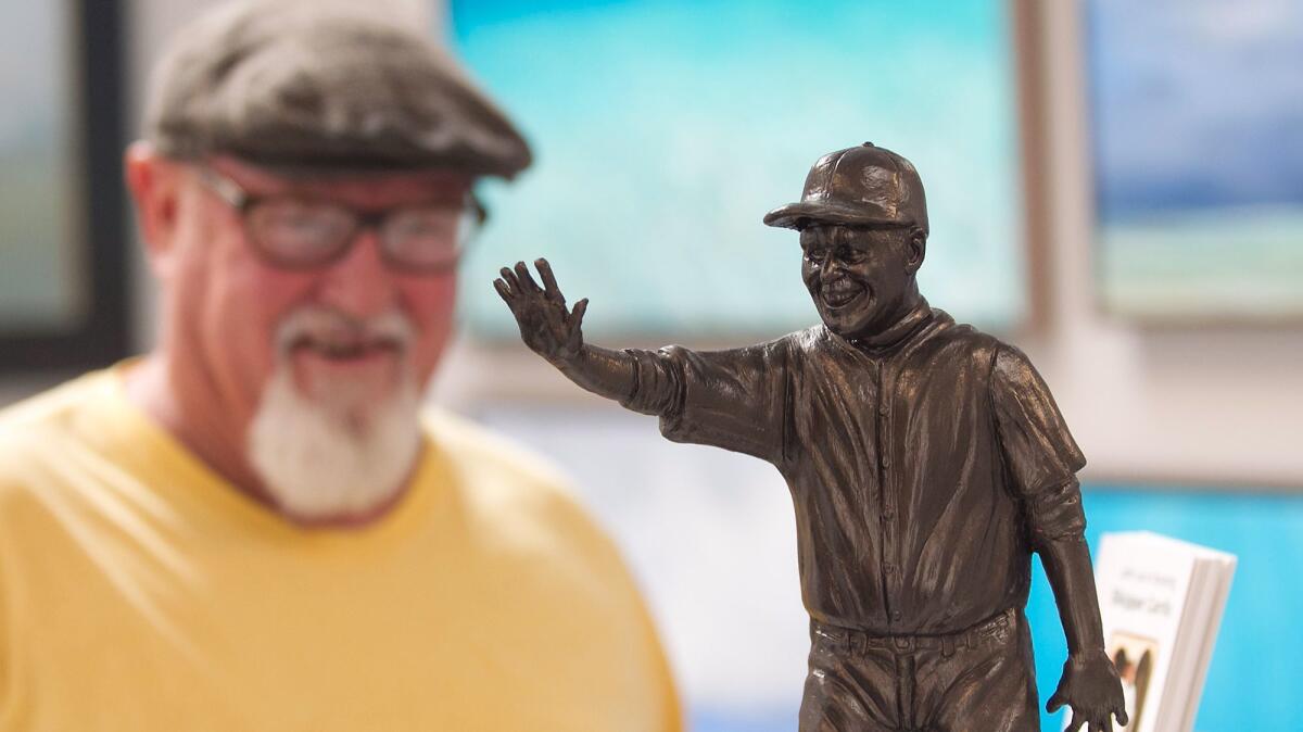 Artist Randy Morgan stands near his model of Skipper Carrillo at the Forest & Ocean Gallery. Gallery owner Ludo Leideritz and Morgan have kick-started a fundraising effort for a life-sized statue of Carrillo, a devoted volunteer at Laguna Beach High.