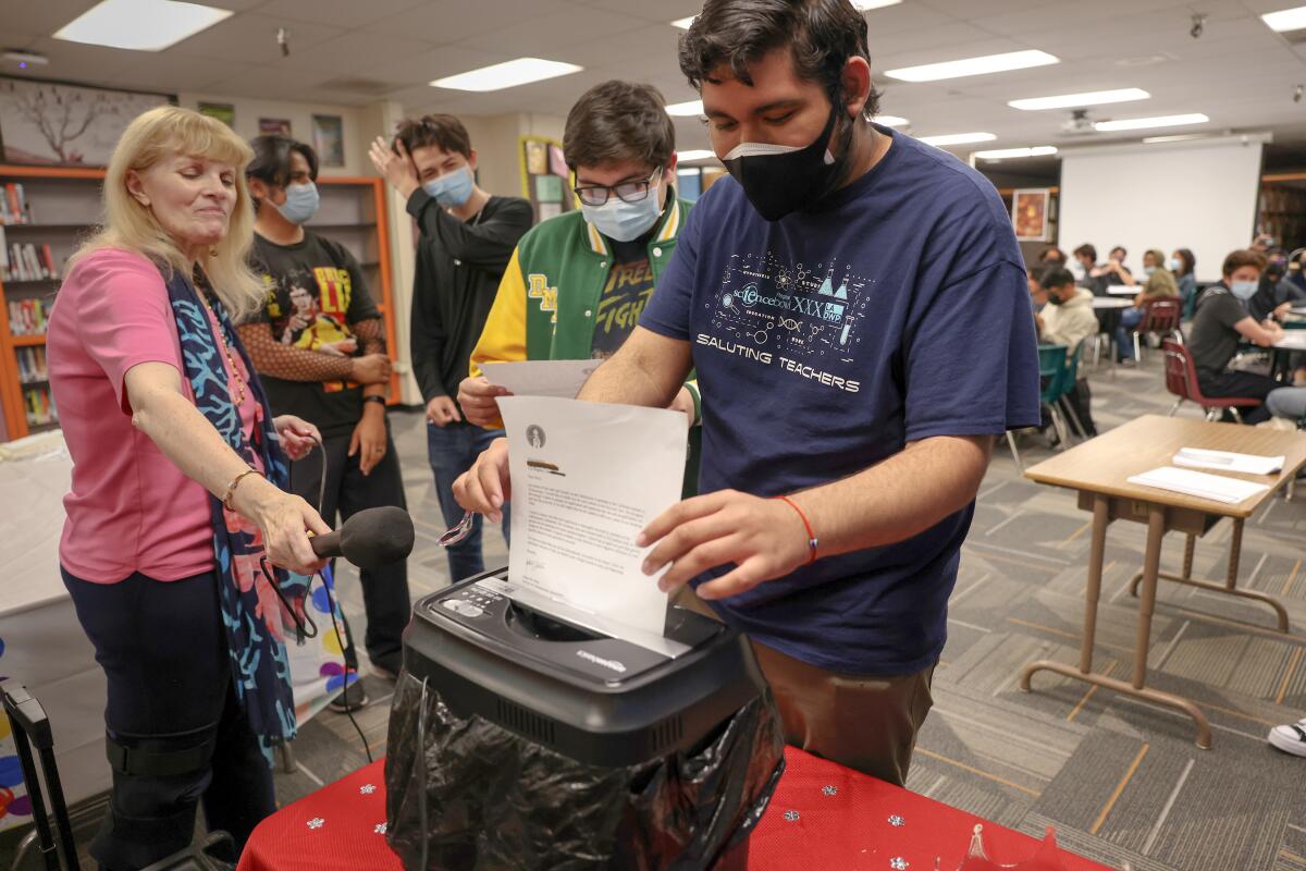 A Downtown Magnets High School senior shreds a rejection letter during a party put on by counselor Lynda McGee April 6. 