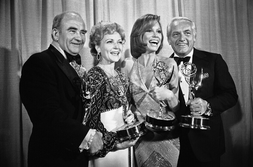 Two men and two women hold Emmy statuettes