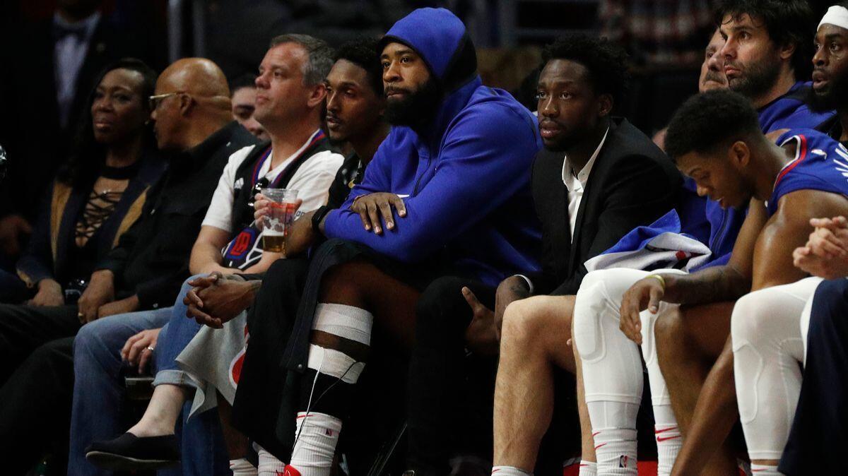 Clippers center DeAndre Jordan, middle, sits out with a left ankle sprain against the Sacramento Kings on Saturday. He missed Monday's game as well.