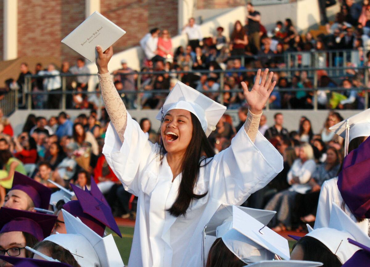 Graduate Mikaela Mauricio, with her diploma in hand, celebrates with friends at the Hoover High School graduation ceremony in Glendale on Wednesday, June 1, 2016.