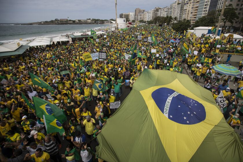 Supporters of Brazilian President Jair Bolsonaro carry Brazil's national flag along Copacabana Beach on Independence Day in Rio de Janeiro, Brazil, Tuesday, Sept. 7, 2021. (AP Photo/Bruna Prado)