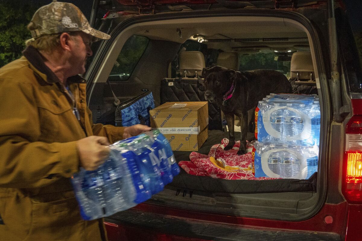 John Beezley, de Bonham, carga varios paquetes de agua embotellada después de enterarse que se emitió un aviso para hervir agua para toda la ciudad de Houston, el domingo 27 de noviembre de 2022, en un Walmart en Houston. (Mark Mulligan/Houston Chronicle via AP)