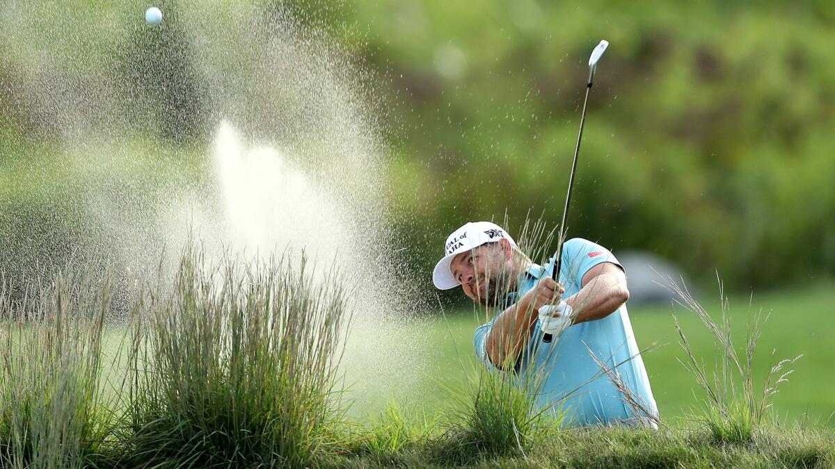 Ryan Moore hits out of a fairway bunker at No. 18 during the first round of the Deutsche Bank Championship on Friday.