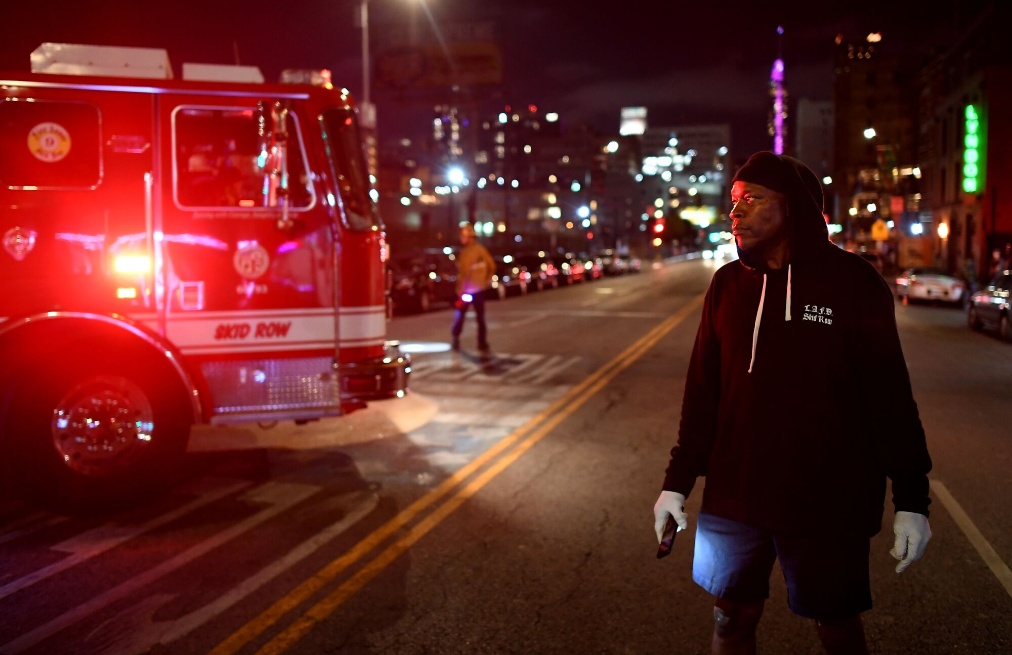 A homeless man known as Mango helps block traffic for firetrucks to exit