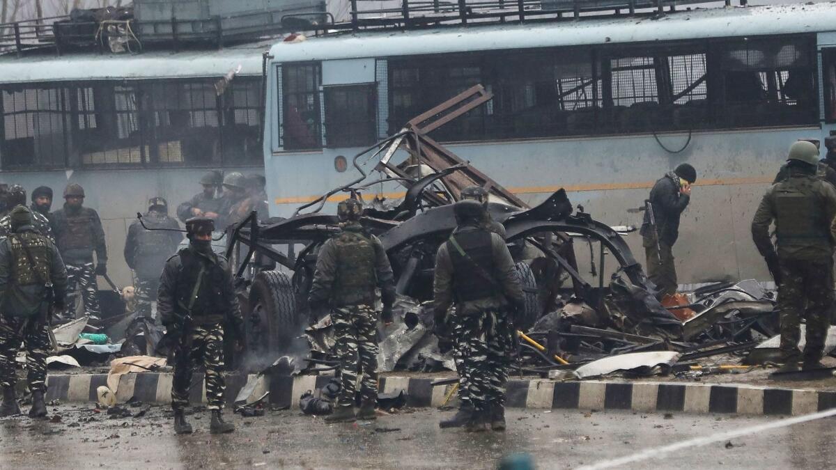 Indian security forces inspect the wreckage of a bus following an attack on a paramilitary Central Reserve Police Force convoy near Awantipora town in Kashmir on Thursday.