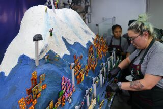 Una pastelera corta un pastel con la forma del monte Illimani en La Paz, Bolivia, el viernes 14 de julio de 2023. Los pasteleros crearon el pastel gigante con la forma del emblemático nevado que rodea la ciudad de La Paz. (AP Foto/Juan Karita)