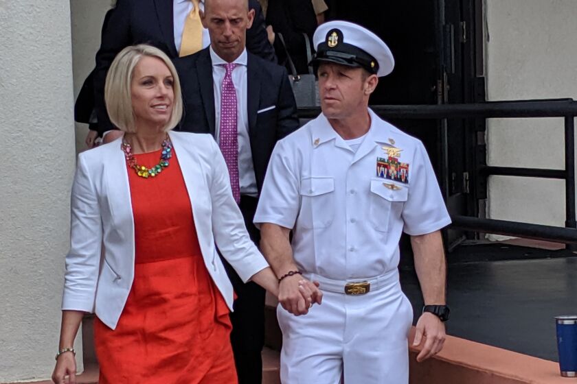 Navy Special Operations Chief Edward Gallagher leaves a military courtroom on Naval Base San Diego with his wife, Andrea Gallagher, on Thursday. Walking out with them is Mark Mukasey, GAllagher's co-counsel and President Donald Trump's personal attorney.