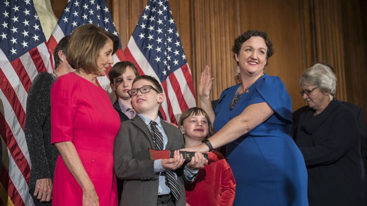 Rep. Katie Porter (D-Irvine) is surrounded by her family as she takes a ceremonial oath with Speaker Nancy Pelosi.