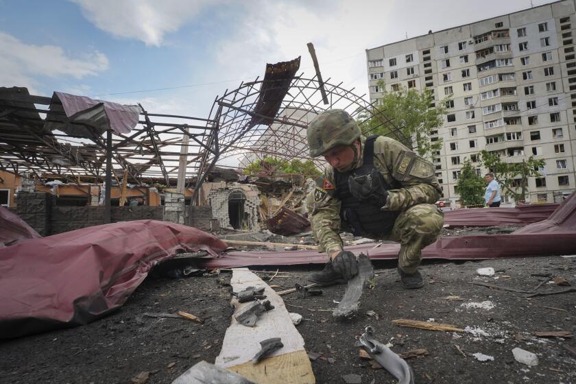 A sapper inspects fragments of a Russian air bomb that hit a living area injuring ten in Kharkiv, Ukraine, Wednesday, May 22, 2024. (AP Photo/Andrii Marienko)