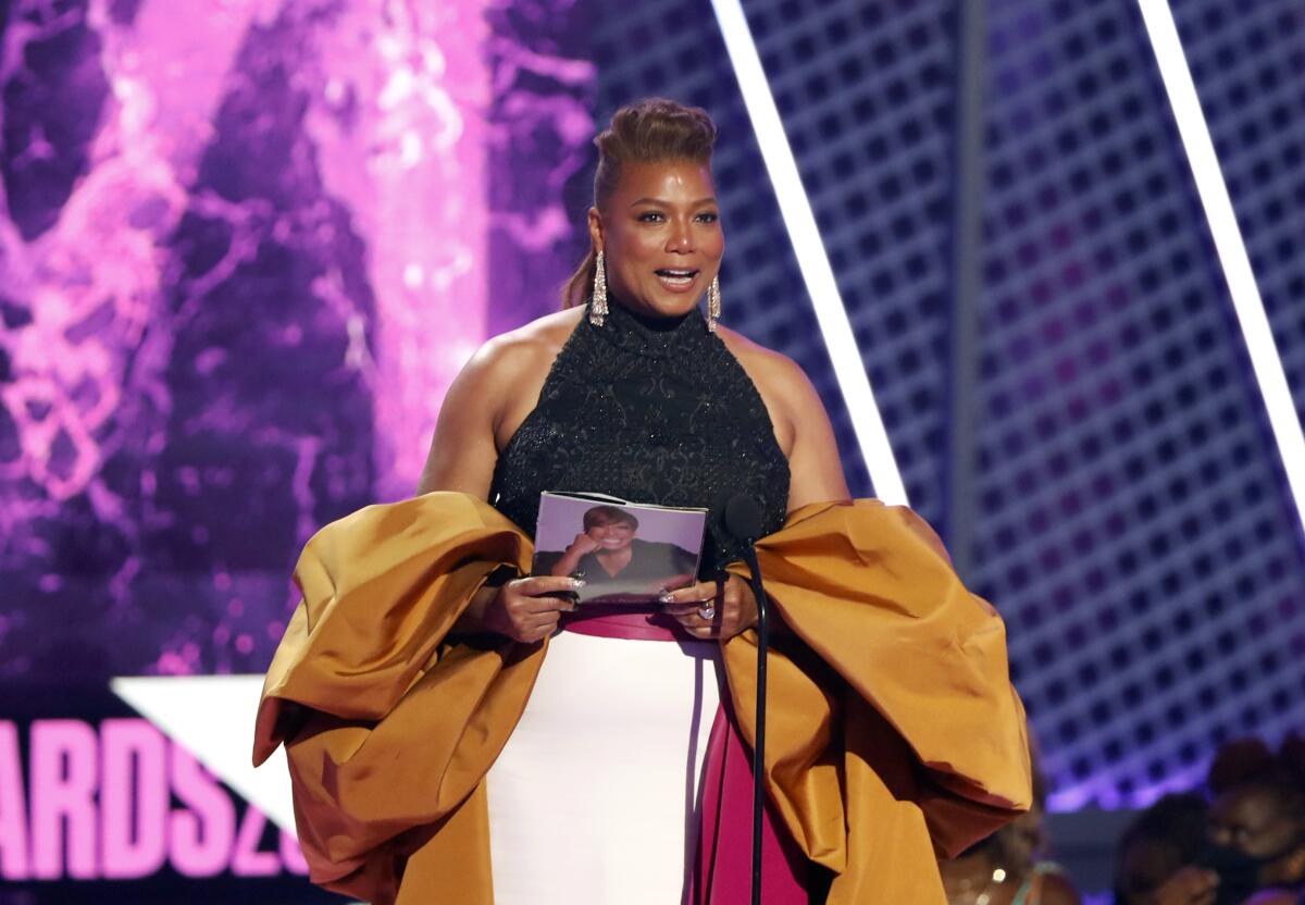 A woman in formal attire accepts an award onstage