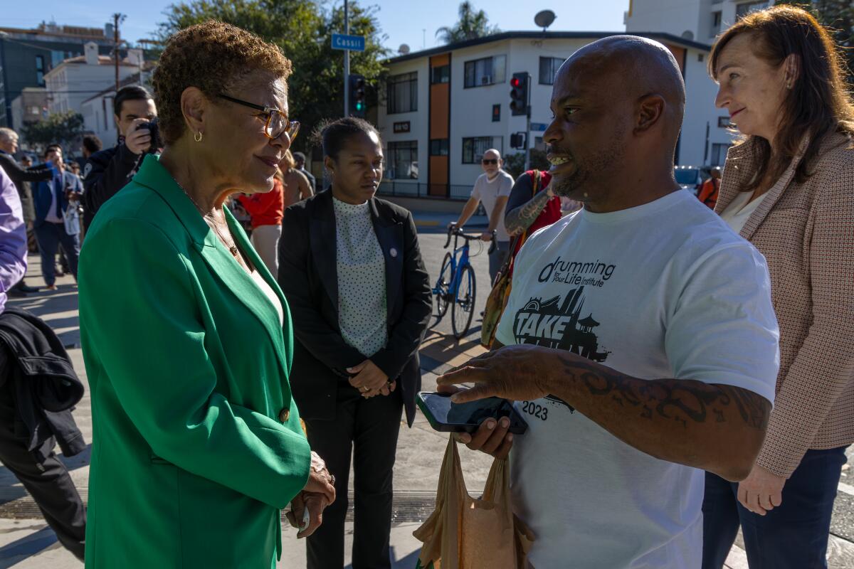 Mayor Karen Bass speaks Darnell Woods in the 6600 block of Selma Avenue following a homeless clean-up on Dec. 6.