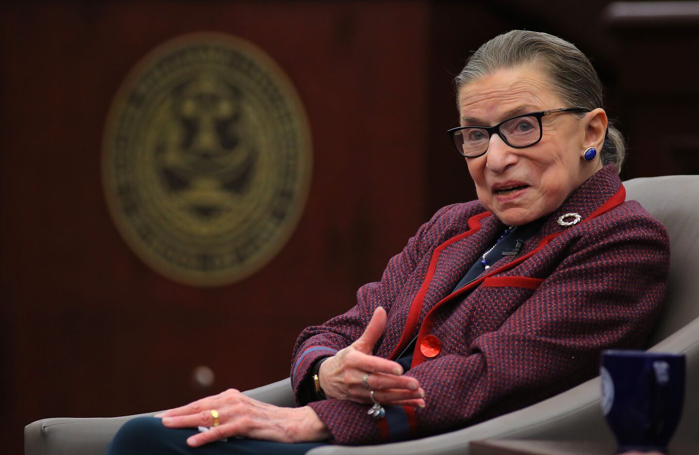 Ruth Bader Ginsburg sits back in a chair while speaking at a law school