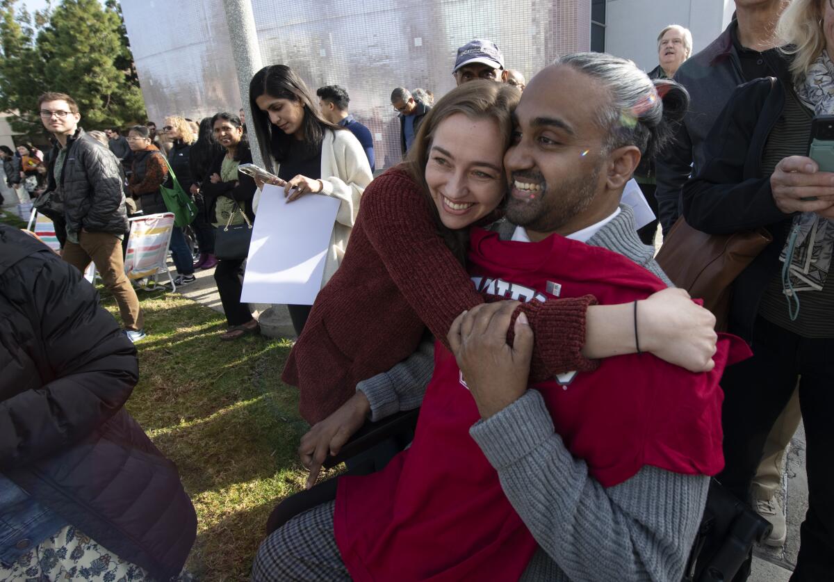 UCI medical student Hinesh Patel gets a hug from wife Emma Bindloss.