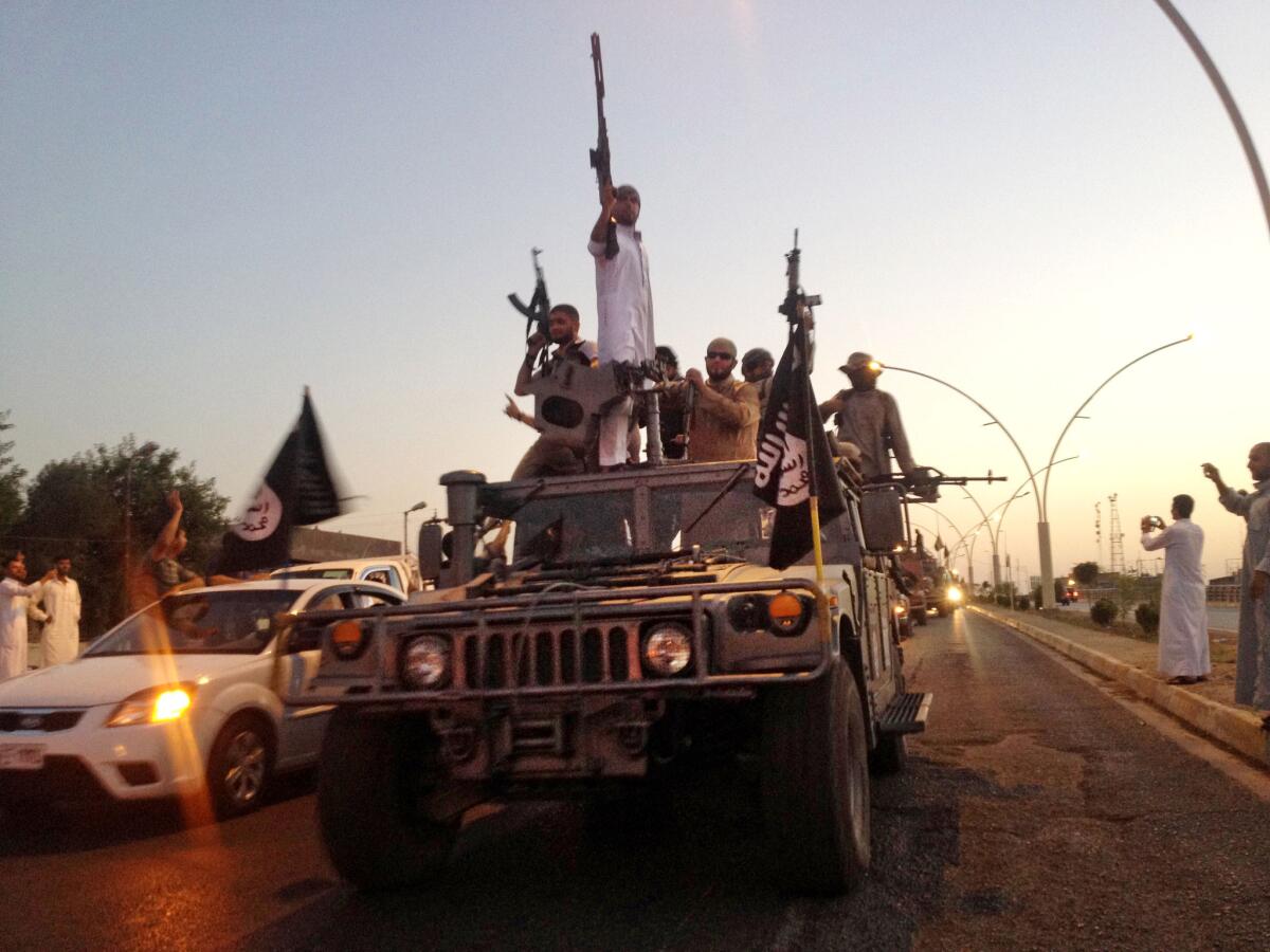 Militants from the Islamic State parade in a commandeered Iraqi security forces armored vehicle on a main street in Mosul, Iraq, in June.