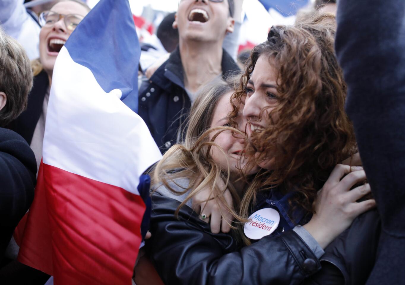 Supporters of French independent centrist presidential candidate, Emmanuel Macron react outside the Louvre museum in Paris, France, Sunday, May 7, 2017. Polling agencies have projected that centrist Emmanuel Macron will be France's next president, putting a 39-year-old political novice at the helm of one of the world's biggest economies and slowing a global populist wave. The agencies projected that Macron defeated far-right leader Marine Le Pen 65 percent to 35 percent on Sunday.