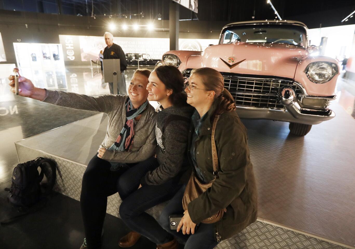 Visitors take a selfie in front of Elvis Presley's pink 1955 Cadillac Fleetwood on display at the Presley Motors Automobile Museum within the new Elvis Presley's Memphis complex in Memphis, Tenn.