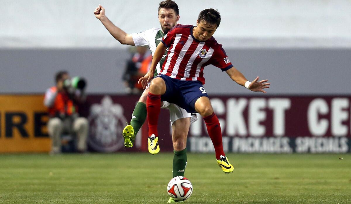Chivas USA forward Erick Torres tries to maintain control of the ball after a challenge by Timbers defender Danny O'Rourke during a game Wednesday at StubHub Center.