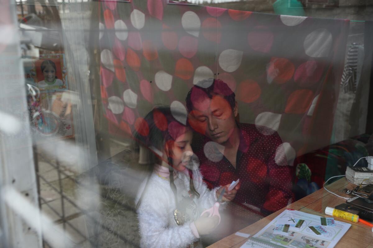 José Collantes Navarro helps his daughter Kehity do homework last month in Santiago, Chile. 