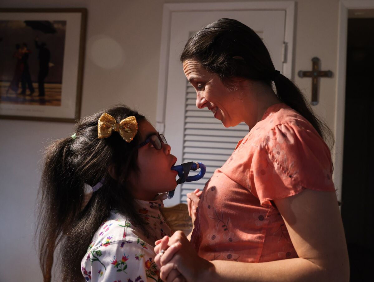 A mother dances with her 9-year-old daughter, who has special needs.