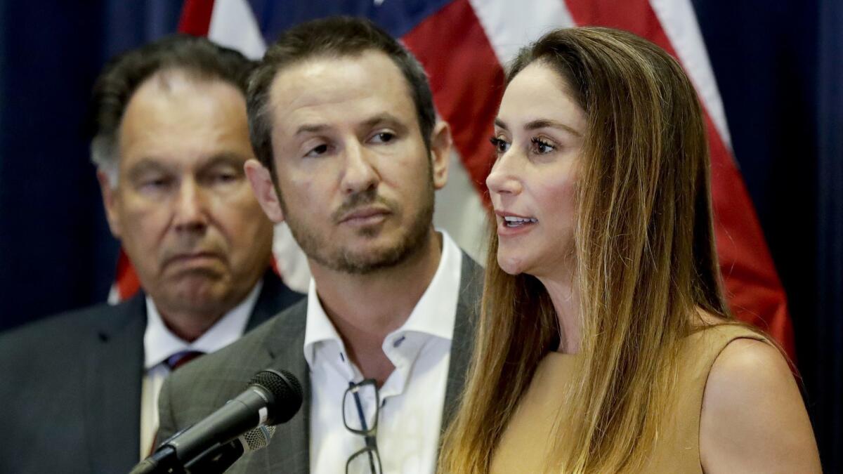Blaze Bernstein’s parents, Gideon and Jeanne, speak at a news conference Thursday as Orange County District Attorney Tony Rackauckas, left, looks on. Prosecutors filed a hate-crime sentencing enhancement allegation against Samuel Woodward, who is accused of murdering Bernstein.